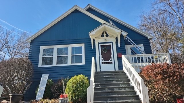 Blue home exterior with white trim repaint