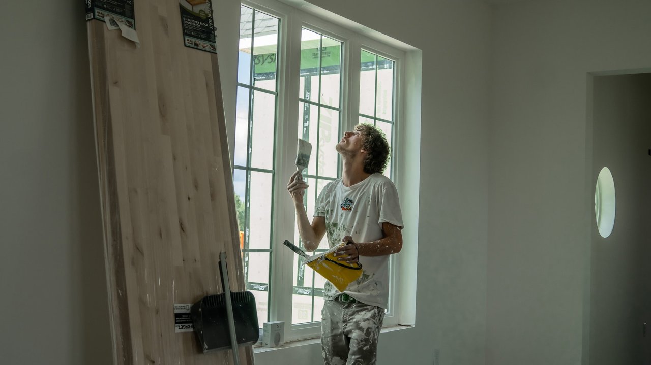 Painter working at an interior window